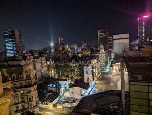 A night view of Buenos Aires cityscape with illuminated buildings, historical architecture, and bustling streets, capturing the vibrant atmosphere of Argentina’s capital.